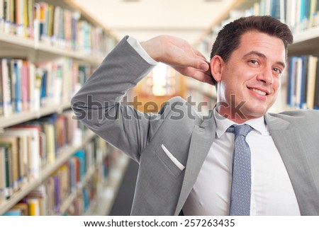Business man with grey suit. He is posing funny. Over library background