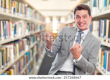 Business man with grey suit. He is ready to fight. Over library background