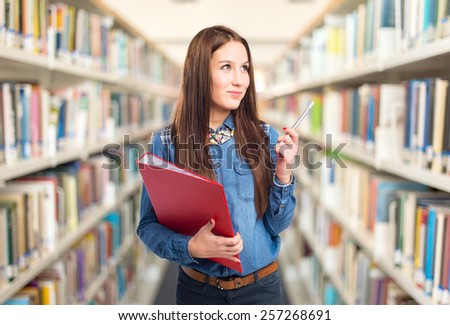 Trendy young woman with a red folder and a pen. Over library background