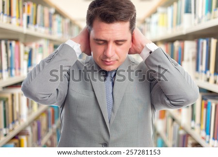 Business man with grey suit . He looks tired. Over library background