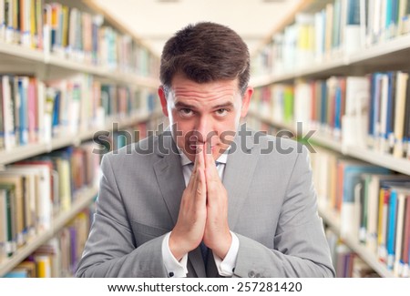 Business man with grey suit. He is begging. Over library background