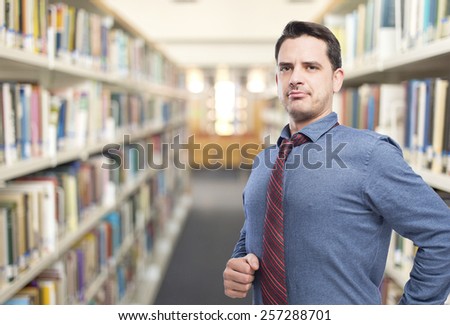 Man wearing a blue shirt and red tie. He looks happy. Over library background