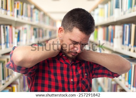 Man with red squares shirt. He looks tired. Over library background