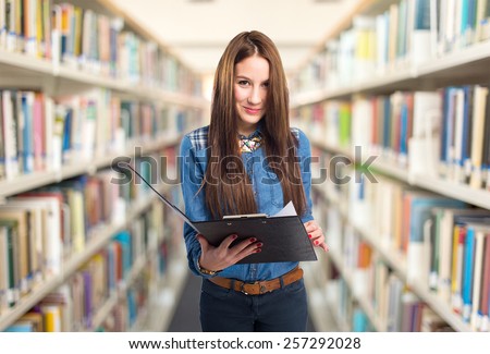 Trendy young woman holding a black folder. She looks funny. Over library background