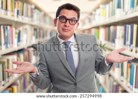 Business man with grey suit. He is looking confused. Over library background