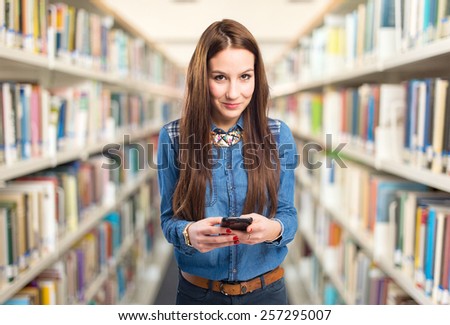 Trendy young woman using a smart phone. Over library background