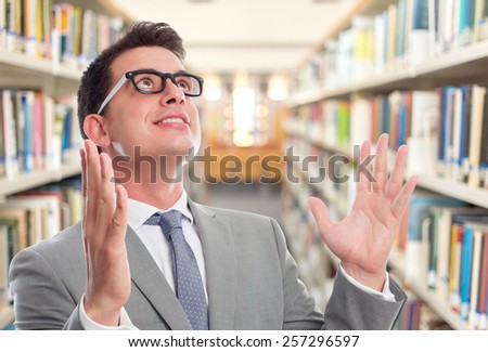 Business man with grey suit. He is looking bliss. Over library background