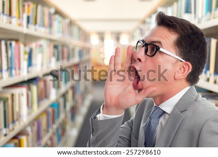 Business man with grey suit. He is screaming. Over library background