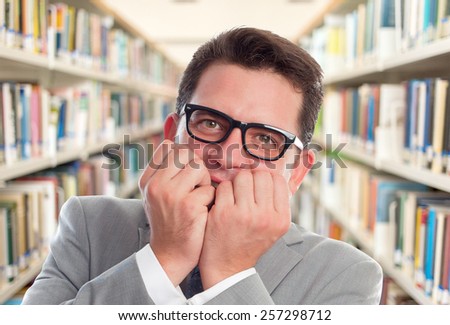 Business man with grey suit. He is looking scared. Over library background