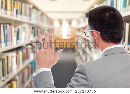 Business man with grey suit swearing. Over library background