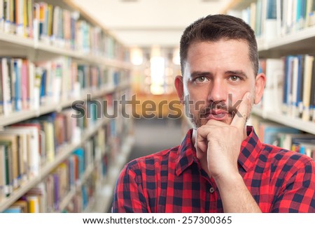 Man with red squares shirt. Portrait. Over library background