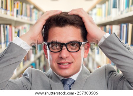 Business man with grey suit looking surprised. Over library background