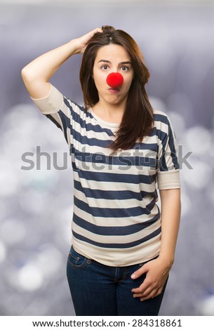 Confused woman with clown nose. Over abstract background