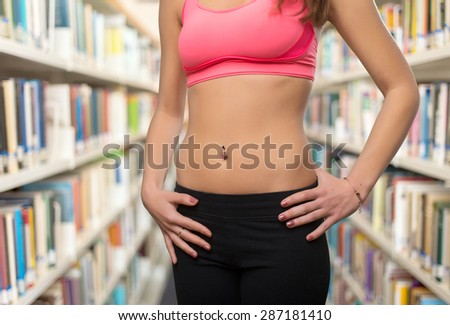Young woman slim belly closeup. Over library background