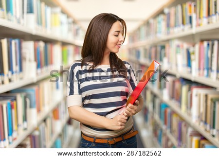 Confident woman holding a red folder. Over library background