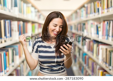 Young woman enjoying with her smart phone. Over library background