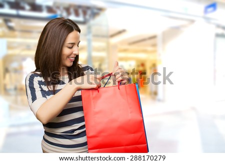 Smiling woman with two shopping bags. Over shopping center background