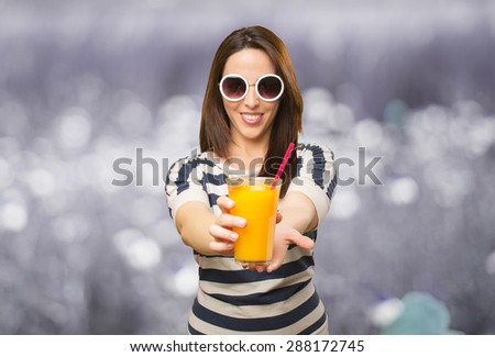 Woman with white sunglasses offering a juice. Over abstract background
