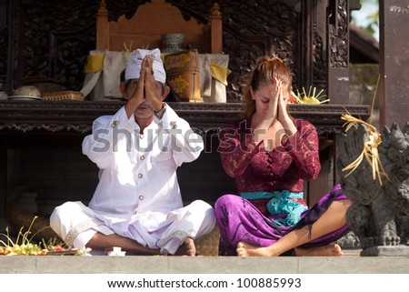 BALI - FEBRUARY 1. Priest praying with worshipper in temple for Galungan ceremony on February 1, 2012 in Bali, Indonesia. Galungan\'s a Balinese holiday occuring every 210 days lasting 10 days.