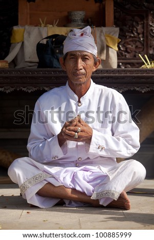 BALI - FEBRUARY 1. Hindu priest praying in local temple for Galungan ceremony on February 1, 2012 in Bali, Indonesia. Galungan\'s a Balinese holiday occuring every 210 days lasting 10 days.