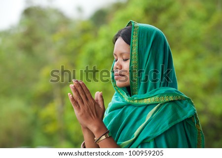 Young south-east asian woman praying with head dress