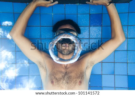 Man making bubble rings underwater in pool