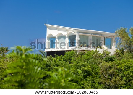 White residential house above the tree tops in tropical Bali, Indonesia