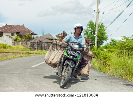 BALI - FEBRUARY 19. Balinese man overloaded with recycled cardboard on scooter on February 19, 2012 in Bali, Indonesia. Most Balinese people cannot afford cars and transport goods by motorcycle.