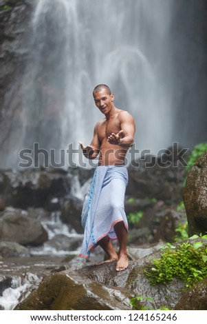 man posing at the jungle waterfall