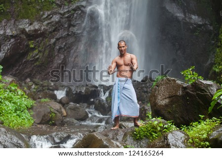 man posing at the jungle waterfall