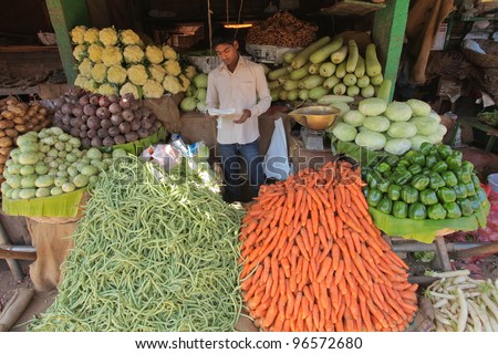 MYSORE - JANUARY 29 : Indian vegetable merchant selling vegetables in Mysore city market on January 29, 2011. India is the second largest producer of vegetables with 14.4% of the world production.