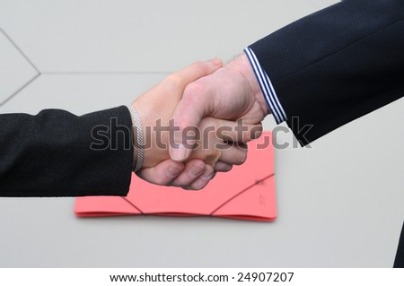 shake hands after successful agreement.Red file on the desk.
