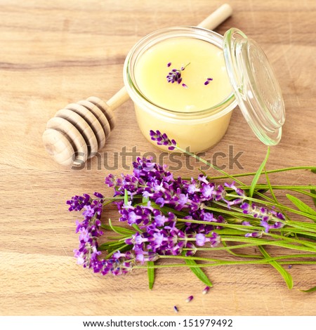 Lavender honey and honey dipper on a wooden table