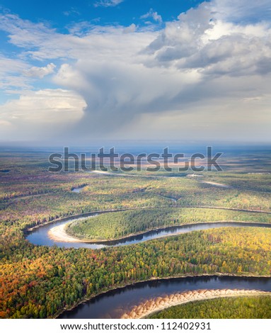 Aerial view of the river executing the loop during the cloudy day of autumn.