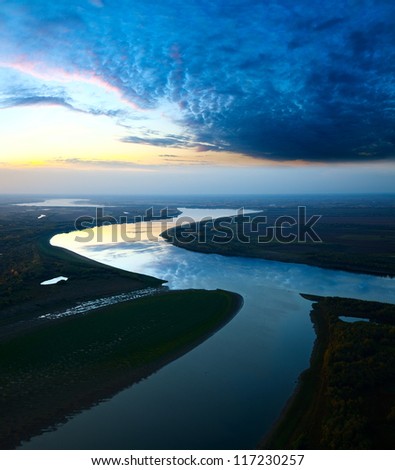 It Is Aerial View The Great River During Twilight. On The River Is Calm Now. Beautiful Clouds Are Reflected In Quiet Water.