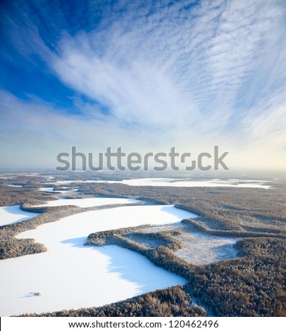 Aerial view of forest plain with lakes during a winter day.
