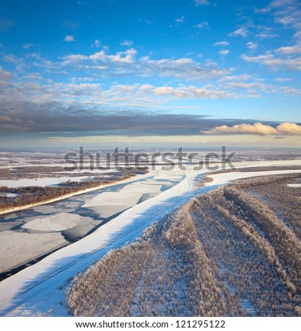 Aerial view of the great river with floating ice floes during the spring day. Drifting of ice. Driving of ice. Ice floe.