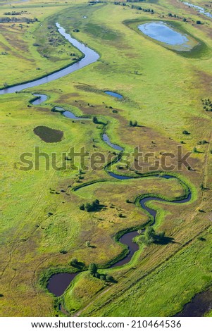 Aerial view the marshy terrain with river and lakes in summer day.