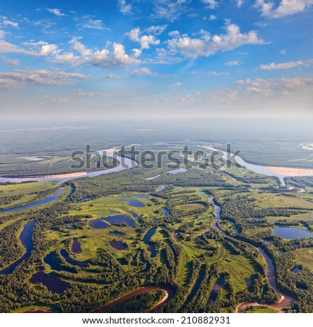 Aerial view the marshy terrain with river and lakes in calm and warm summer evening.