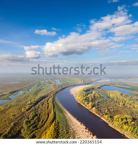Aerial view of great river lowland in autumn. Leafs of trees are painted in different bright colors.