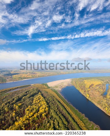 Aerial view of great river lowland in autumn. Leafs of trees are painted in different bright colors.