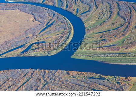 Aerial view of the forest river during autumn. River winds very strong.