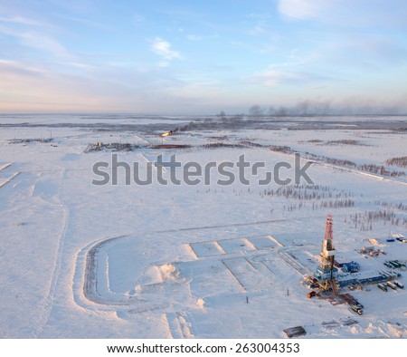 Aerial view of oil rig at an oil field in Western Siberia in the winter day. Gas-jet for gas flaring is located near the rig.