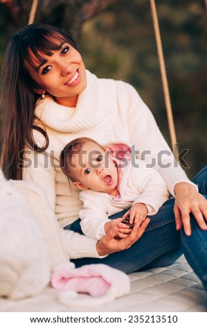 Mother and baby daughter go for a drive on swing