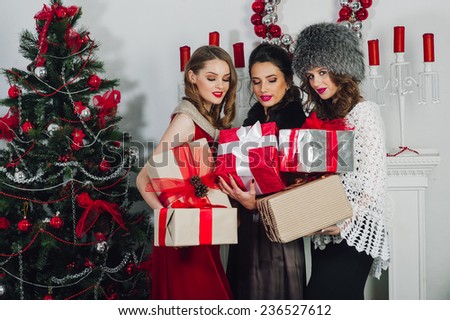 Three beautiful girl near the Christmas tree