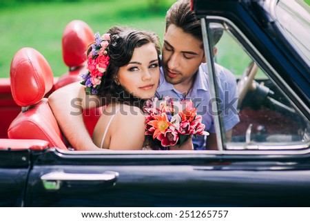 Young couple in vintage cars