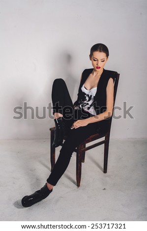 beautiful girl model sits on a chair in the studio