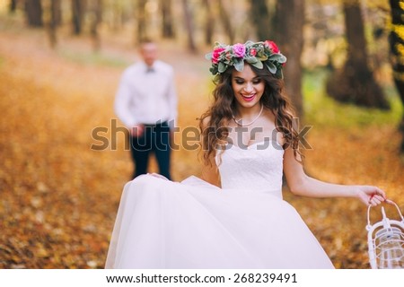 happy bride and groom walking in the autumn forest