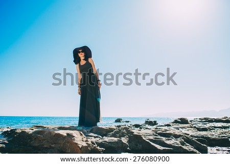 Beautiful charming girl posing against the blue sky during summer time
