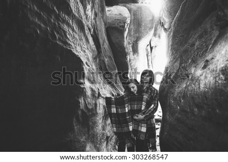 A young couple holding hands on the background of the fantastic gorges in the Carpathian Mountains, rocks Dovbush